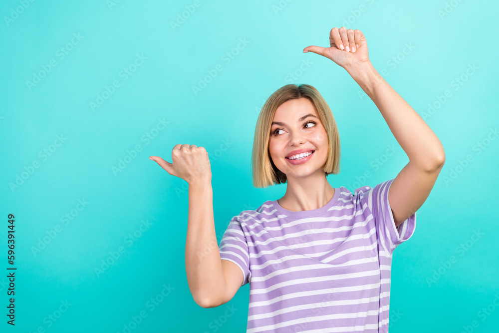 Photo of young girl wear stylish t-shirt direct fingers looking empty space proposition hypermarket offer isolated on blue color background Photo of young girl wear stylish t-shirt direct fingers looking empty space proposition hypermarket offer isolated on blue color background