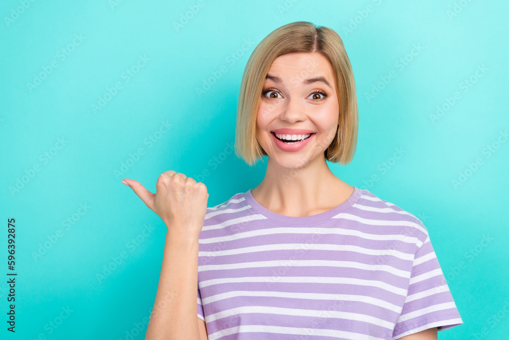 Portrait of impressed cheerful woman short haircut wear stylish t-shirt directing empty space billboard isolated on teal color background Portrait of impressed cheerful woman short haircut wear stylish t-shirt directing empty space billboard isolated on teal color background