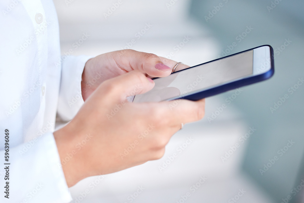 Most things can be done with just a click nowadays. Cropped shot of an unrecognizable woman using her cellphone at the office.