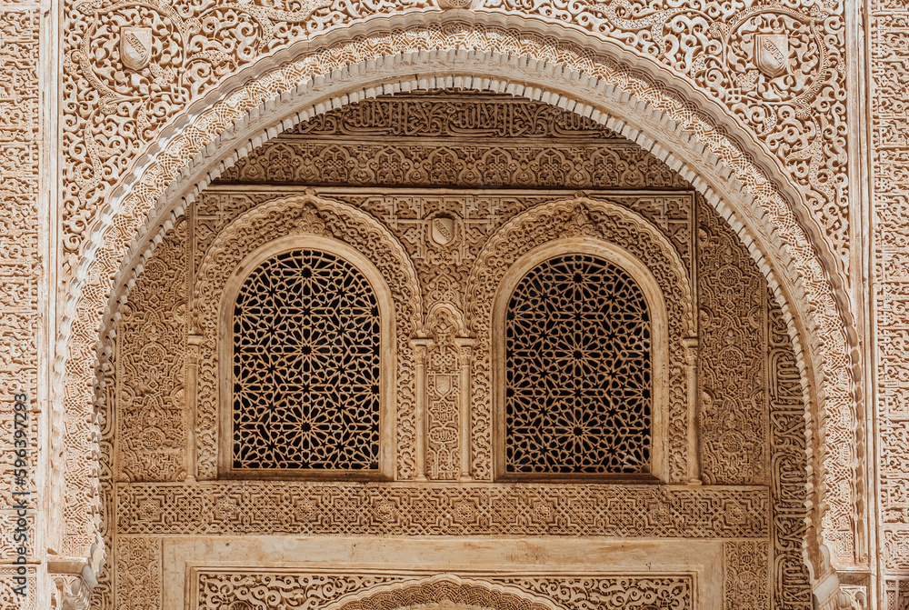  Marble capitals and stucco decoration of the portico in Patio del Cuarto Dorado in Mexuar in Comares Palace Alhambra, Andalusia, Spain. Magic breathtaking carved decoration  in orient style.