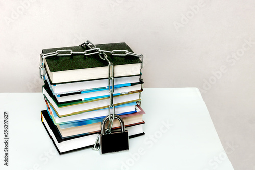 stack of books wrapped in a chain and padlocked photo