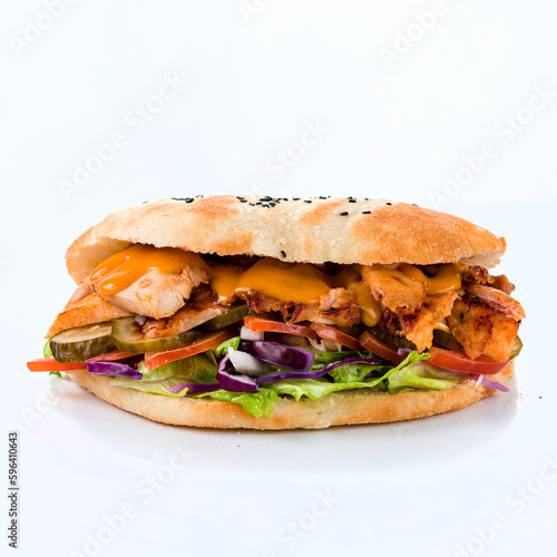 Flatbread with tomatoes, chicken, lettuce, cheese, pickled cucumbers, cabbage and sauce on white background.