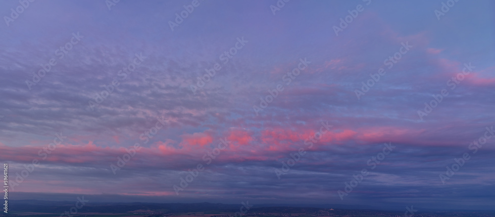 Aerial, large panoramic view  of colorful, blue, pink and red colored evening sky without obstacles in the front. Ideal for sky replacement projects. 