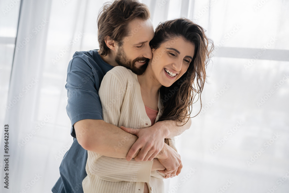 Overjoyed man hugging brunette girlfriend at home in morning. Overjoyed man hugging brunette girlfriend at home in morning.