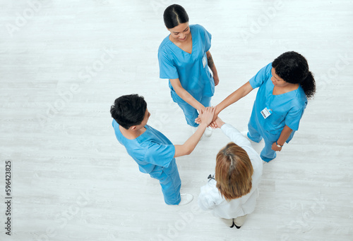 Hope in scrubs. Above shot of a group of medical practitioners joining their hands together in a huddle. © K.A./peopleimages.com
