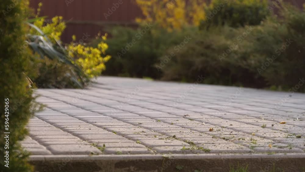 a woman sweeps the cobblestones a woman sweeps the cobblestones