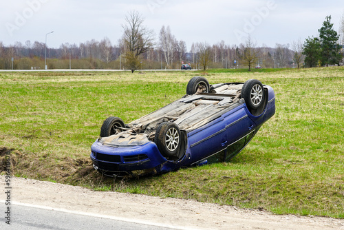 Car accident scene, a passenger car left the road and overturned upside, car rollover