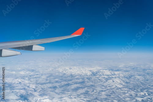 View from the airplane window. The wing of an aircraft during a flight in daylight at high altitude.