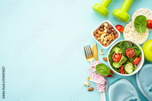 Healthy lifestyle, diet and losing weight background. Sport shoes, dumbell and healthy food with measuring tap on blue. Flat lay with copy space.