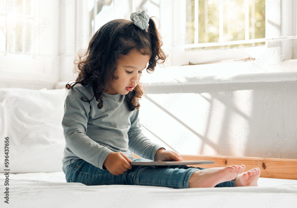 Screen timemom time. Shot of an adorable little girl sitting on her bed with a digital tablet. Screen timemom time. Shot of an adorable little girl sitting on her bed with a digital tablet.