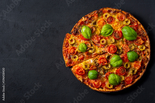 Pizza Margherita with basil tomato and mozzarella, top view on a black background .