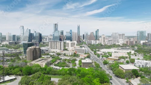 Austin skyscraper buildings skyline video. Drone flying above green suburban park area towards scenic tall business offices buildings. Downtown Austin cityscape on sunny summer day Texas 4K aerial USA photo