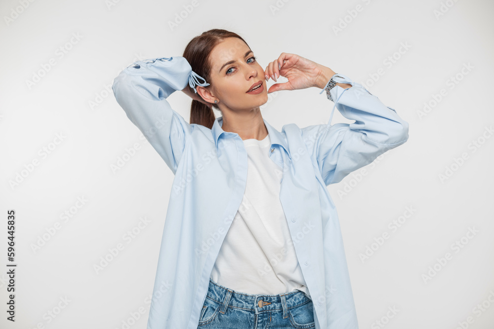 Beautiful young stylish woman with a smile in fashion casual denim clothes with a shirt and jeans on a white background Beautiful young stylish woman with a smile in fashion casual denim clothes with a shirt and jeans on a white background