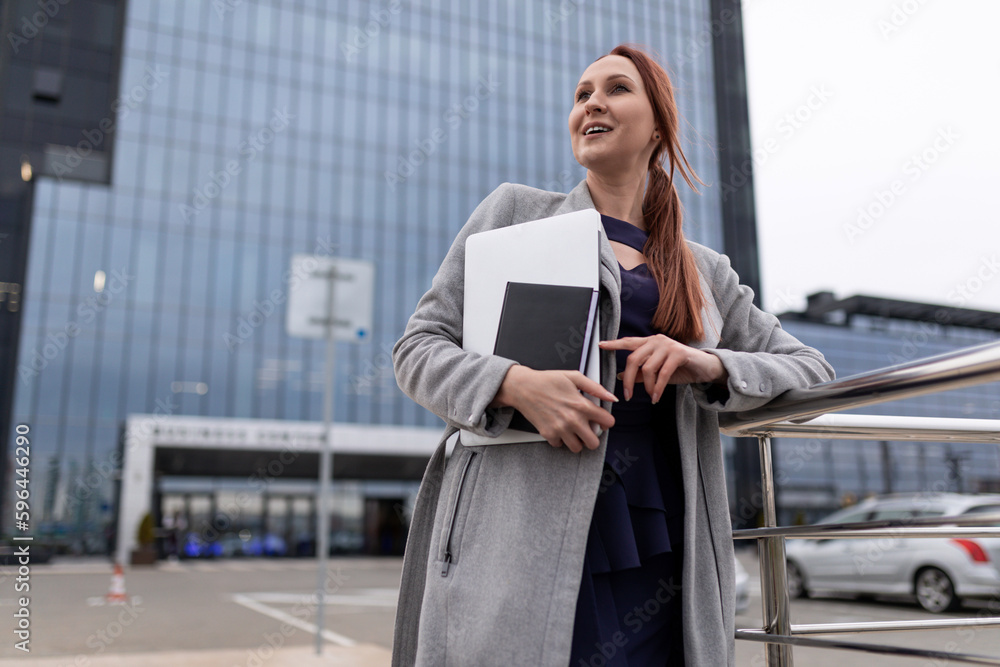 happy young woman architect with construction documents on the background of a freshly built building happy young woman architect with construction documents on the background of a freshly built building