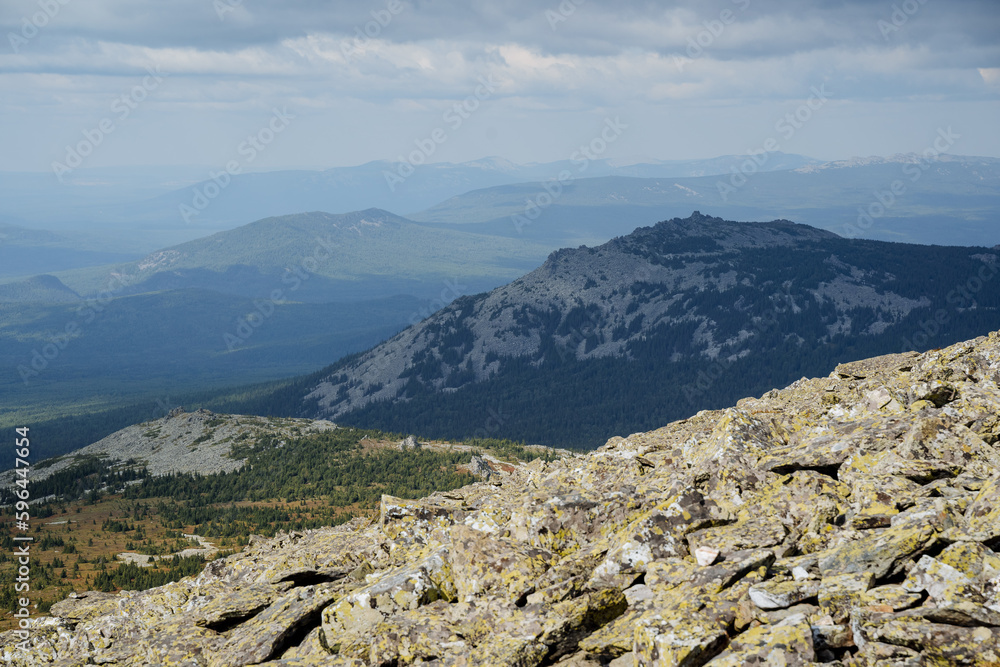 High kurum peaks, mountains crumbled, large stones on the slopes of the ridge, a panorama of steep mountains, haze in the air, the southern Urals, the beauty of Russia