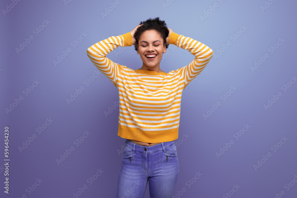 joyful cute brunette curly latin young woman in yellow striped sweater joyful cute brunette curly latin young woman in yellow striped sweater