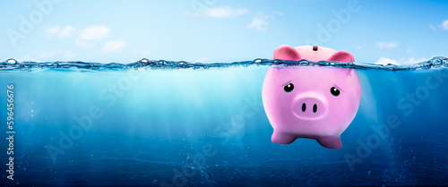 Pink Piggy Bank Drowning In Clear Blue Waters - Financial Debt Concept