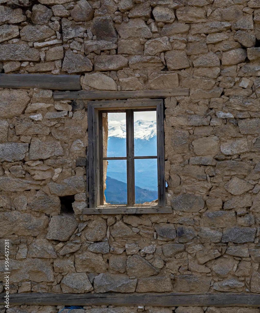 old window in the old wall seeing the beautiful snowy mountains old window in the old wall seeing the beautiful snowy mountains