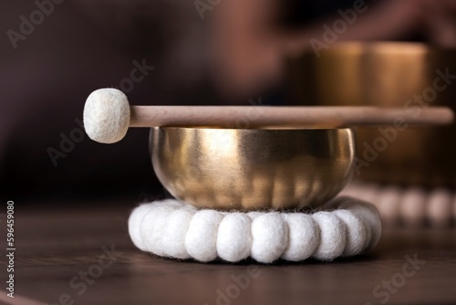 Fotografiet A portrait of a tibetan singing bowl or himalayan bowl, with a mallet lying on top of it to make a relaxing sound