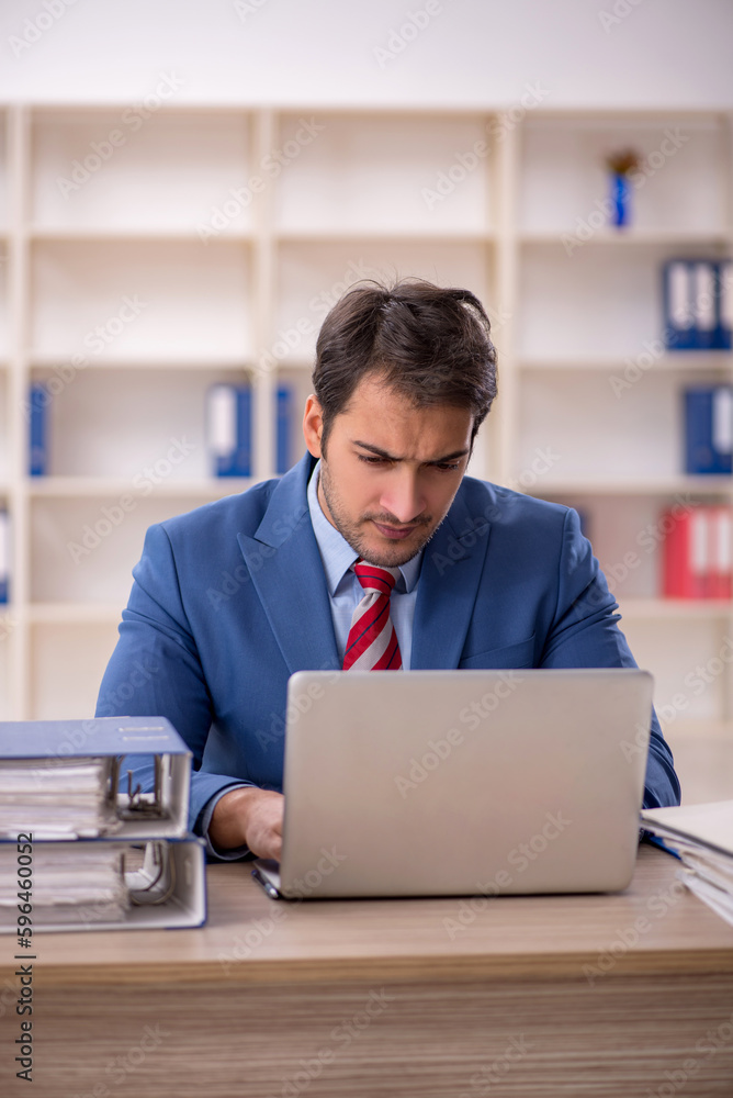 Young male employee working in the office Young male employee working in the office