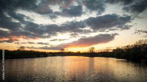 Sunset with dark clouds with reflection in a lake