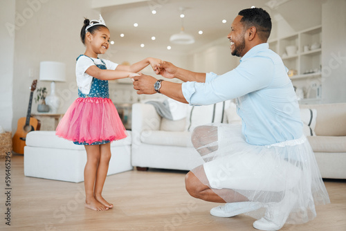 Love your family as you love yourself. Shot of an adorable little girl wearing a tutu and dancing with her father in the living room.