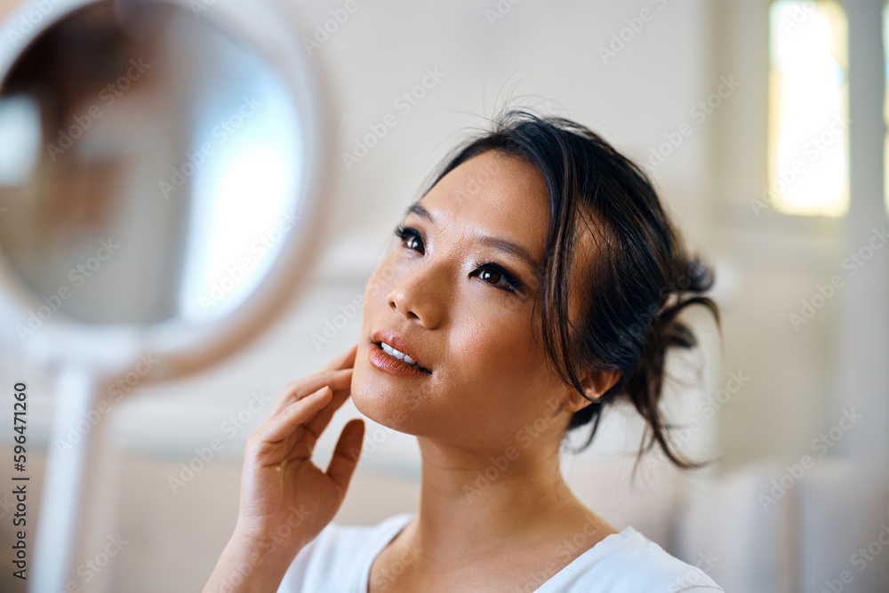 Beautiful Asian woman looking herself in mirror at home. Beautiful Asian woman looking herself in mirror at home.
