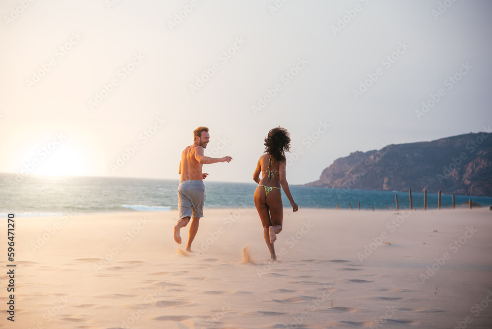 Happy couple running on tropical romantic beach