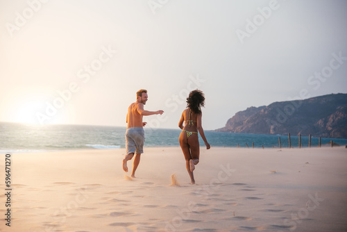 Happy couple running on tropical romantic beach