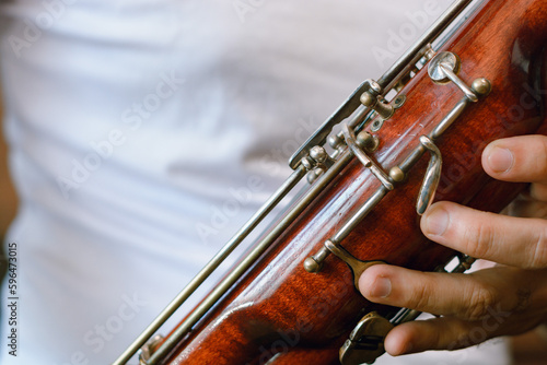 close-up of bassoon body held by a person.