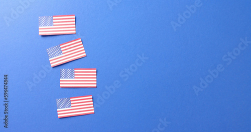 Close up of flags of usa lying on blue background with copy space