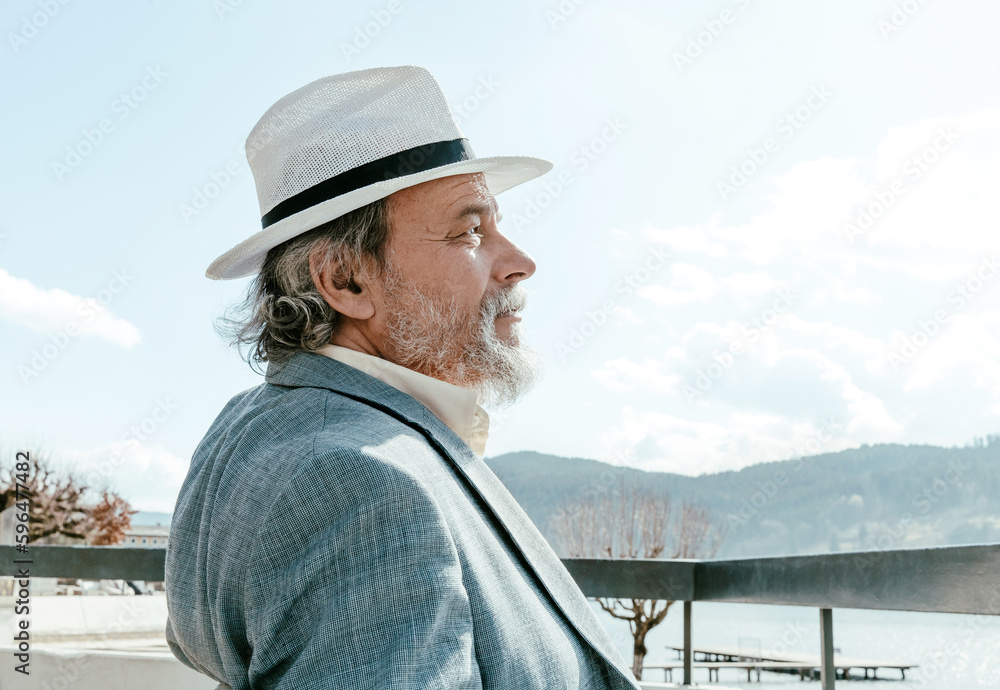 Obraz premium Portrait of a confident, handsome, mature man, pensioner, grandfather in the small town