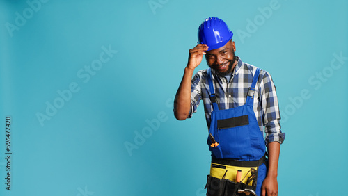 African american craftsman being humble saying hello, acting positive and smiling in studio. Young cheerful putting hat down and showing respect on camera, building carpentry profession.