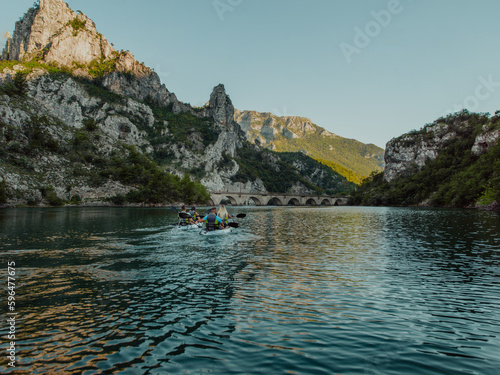 Fototapeta Naklejka Na Ścianę i Meble -  A group of friends enjoying having fun and kayaking while exploring the calm river, surrounding forest and large natural river canyons
