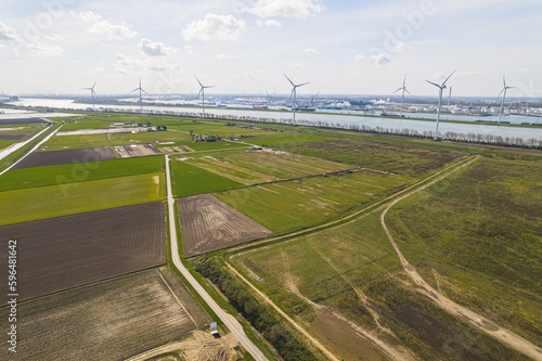 aerial shot of green fields, windmills and a river in the background, sunny day, Botlek, Netherlands. High quality photo