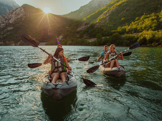 A group of friends enjoying fun and kayaking exploring the calm river, surrounding forest and large natural river canyons during an idyllic sunset.