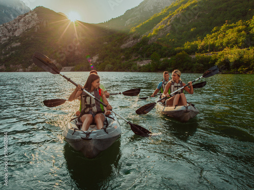 Fotografia A group of friends enjoying fun and kayaking exploring the calm river, surrounding forest and large natural river canyons during an idyllic sunset