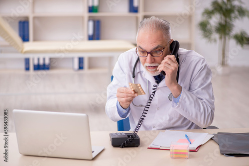 Old male doctor working in the clinic