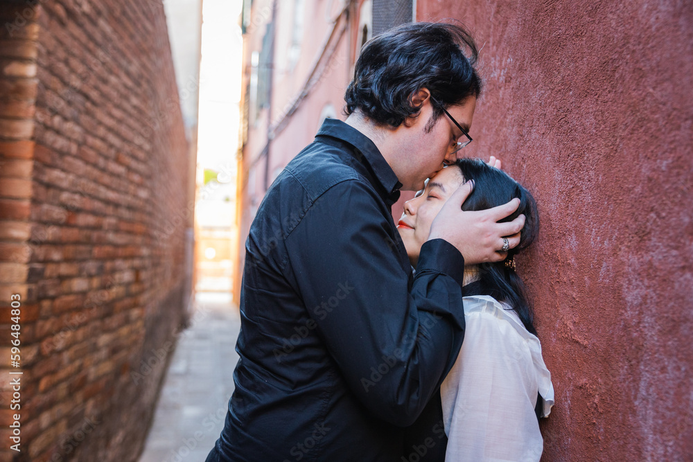 Boyfriend kisses his girlfriend's forehead, mixed couple, moment of passion