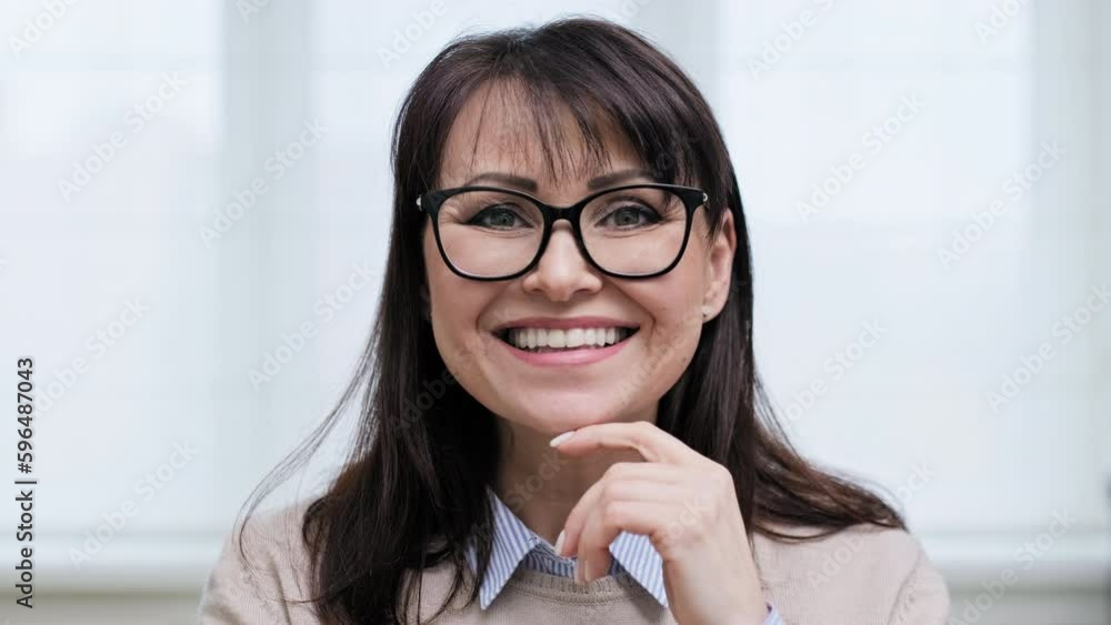 Close-up face portrait of beautiful mature woman with glasses smiling with teeth Close-up face portrait of beautiful mature woman with glasses smiling with teeth