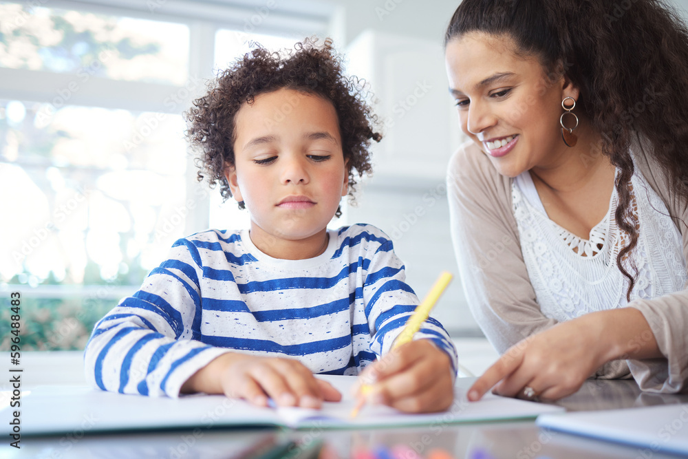 Hes really talented. Shot of a mother helping her son with homework at the kitchen table. Hes really talented. Shot of a mother helping her son with homework at the kitchen table.