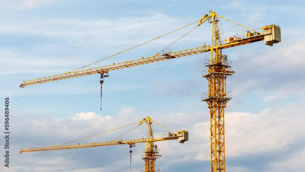 Tower cranes timelapse on the construction site, against dramatic sky
