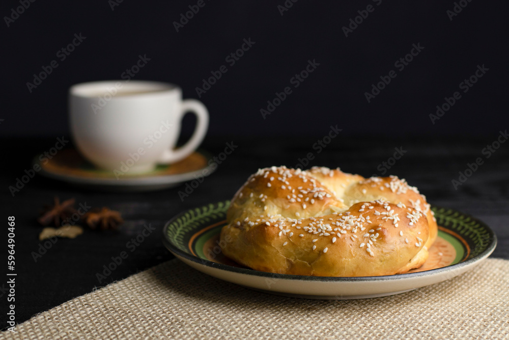 Breakfast at the bakery, afternoon snack, with bread and a cup of coffee. Delicious. Photo with black and blurred background.