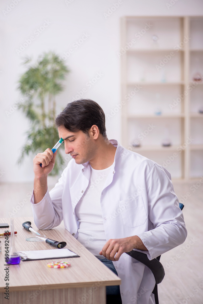 Young male chemist working at the lab Young male chemist working at the lab