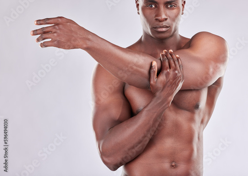 Fitness is my game and Im always prepared. Studio portrait of a muscular young man stretching his arms against a grey background.