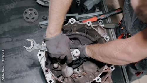 An auto mechanic repairs a gearbox in a modern car. professional car service. Replacement of warranty parts. Close-up shot.