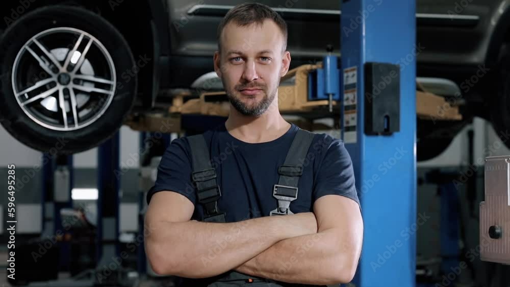Portrait of a professional male mechanic standing in a car repair shop. Portrait of a professional male mechanic standing in a car repair shop.