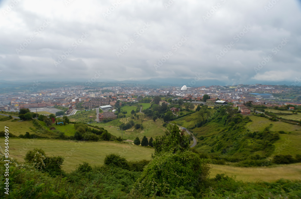 Spectacular views towards the city of Oviedo, from the viewpoint, under a very cloudy sky.