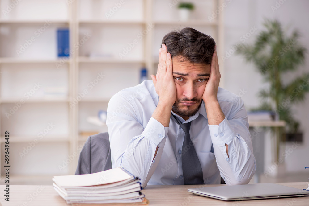 Young male employee working in the office Young male employee working in the office