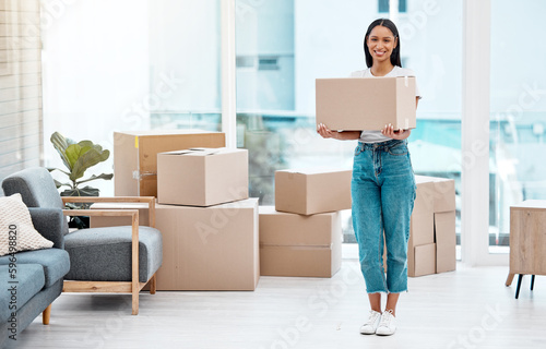 This part gets me excited. Full length shot of an attractive young woman standing alone in her new home and holding a box.